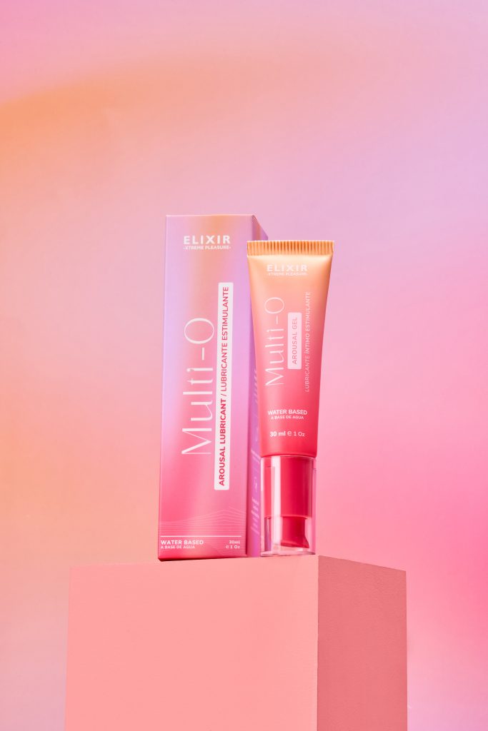 Lubricante íntimo estimulante Multi-O Elixir de 30 ml con extractos naturales y L-arginina, sobre fondo rosa vibrante.
