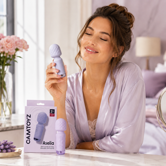 Mujer sosteniendo el Vibrador Aselia Majestic morado junto al producto y su caja CamToyz