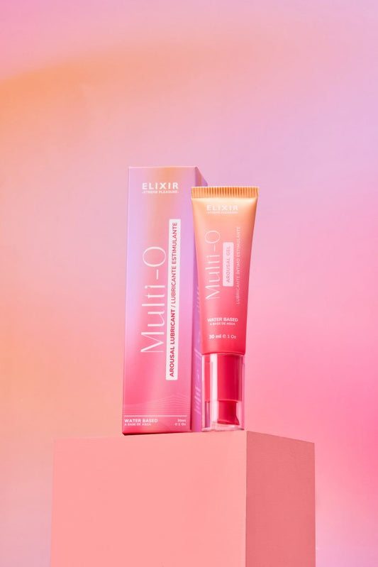Lubricante íntimo estimulante Multi-O Elixir de 30 ml con extractos naturales y L-arginina, sobre fondo rosa vibrante.
