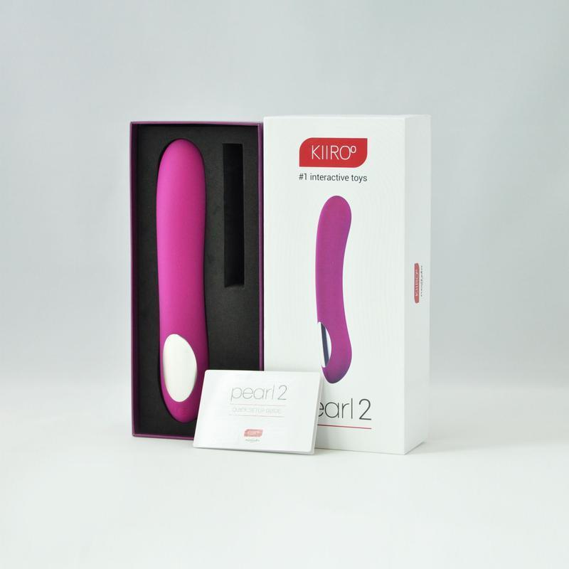 Vibrador Pearl 2 by Kiiroo en color morado dentro de su caja de presentación, junto a un manual de inicio rápido.